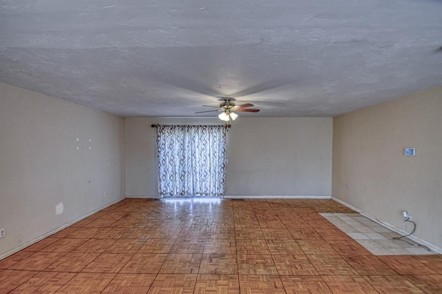 unfurnished room with ceiling fan, a textured ceiling, and baseboards