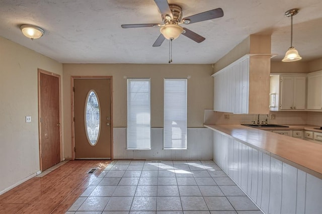 foyer with light tile patterned floors, baseboards, a wealth of natural light, and a ceiling fan