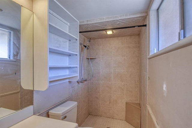 bathroom with toilet and a tile shower