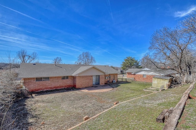 back of property featuring a yard, a shed, an outdoor structure, and fence