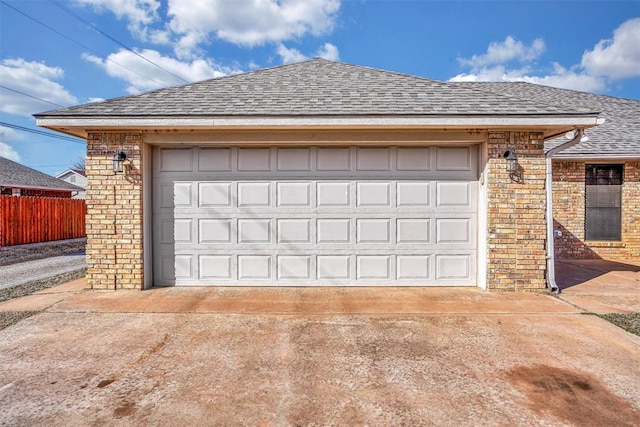 garage with driveway and fence