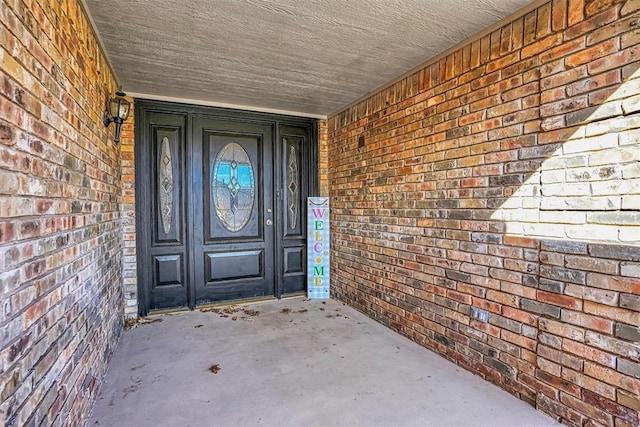 entrance to property featuring brick siding