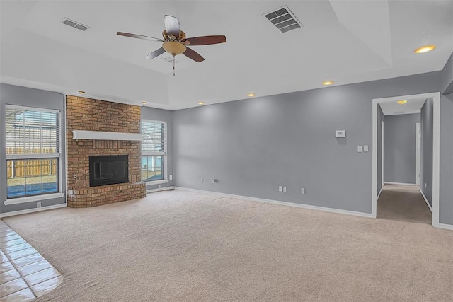 unfurnished living room with a wealth of natural light, a raised ceiling, and visible vents