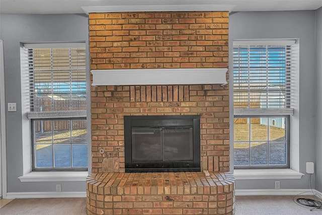 interior details featuring carpet floors, a brick fireplace, and baseboards