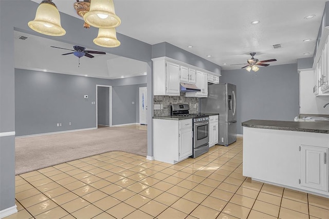 kitchen with open floor plan, appliances with stainless steel finishes, dark countertops, and white cabinetry