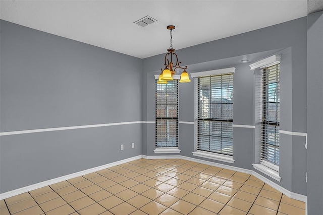 empty room with visible vents, a notable chandelier, baseboards, and light tile patterned floors