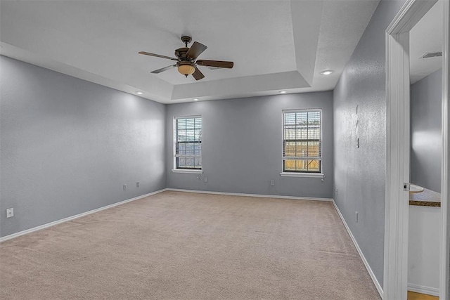 spare room with light carpet, plenty of natural light, and baseboards