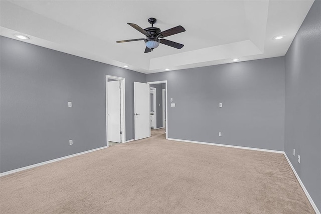 unfurnished room featuring recessed lighting, a raised ceiling, light colored carpet, ceiling fan, and baseboards