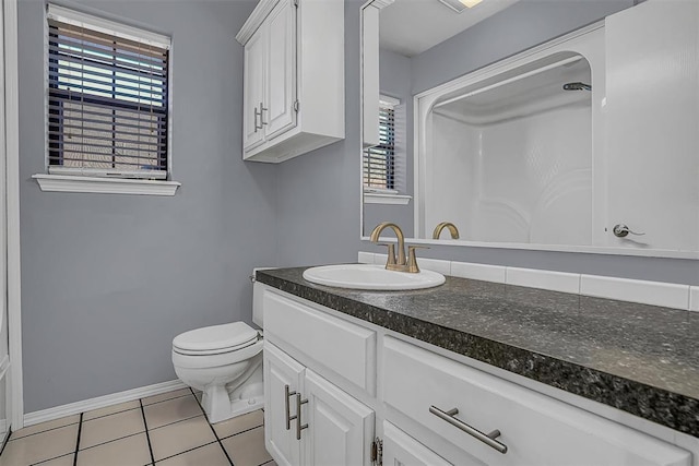 bathroom with tile patterned flooring, a healthy amount of sunlight, vanity, and toilet