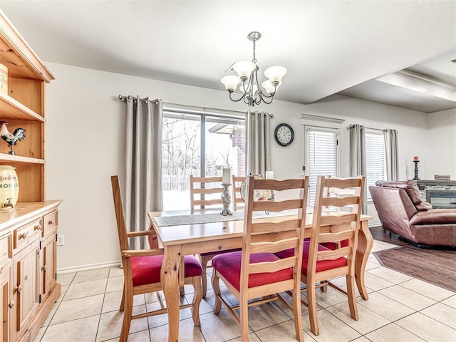 dining room featuring light tile patterned floors, baseboards, and a notable chandelier