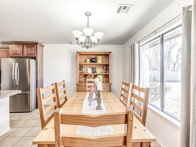 dining area featuring a chandelier, light tile patterned flooring, and visible vents