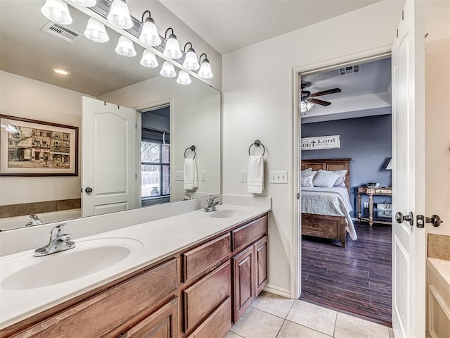 bathroom with connected bathroom, visible vents, and a sink