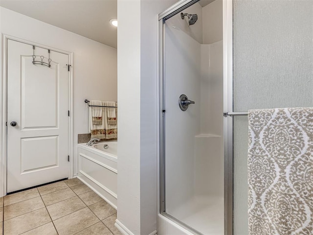 bathroom with a garden tub, a stall shower, and tile patterned flooring