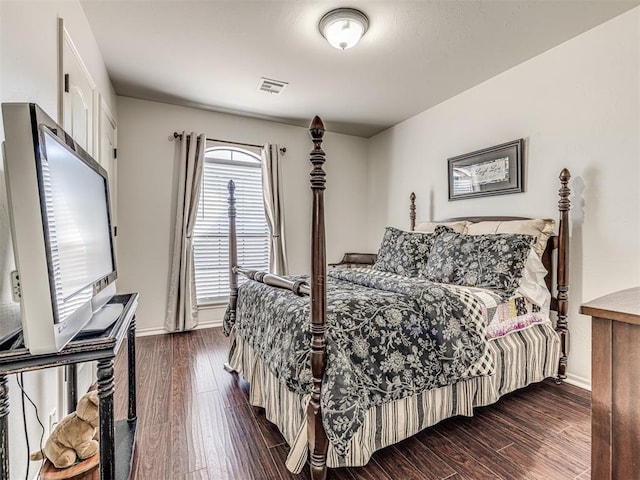 bedroom featuring dark wood-style floors, visible vents, and baseboards