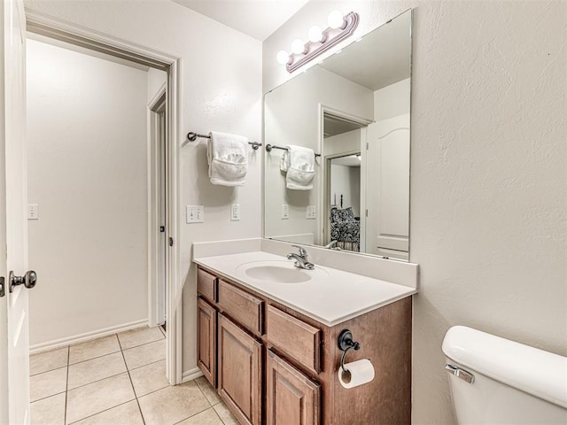 half bath featuring toilet, tile patterned flooring, and vanity