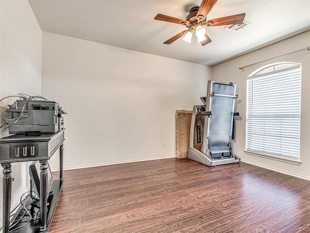 workout room featuring baseboards, ceiling fan, visible vents, and wood finished floors