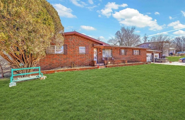 ranch-style home with an attached garage, concrete driveway, brick siding, and a front yard