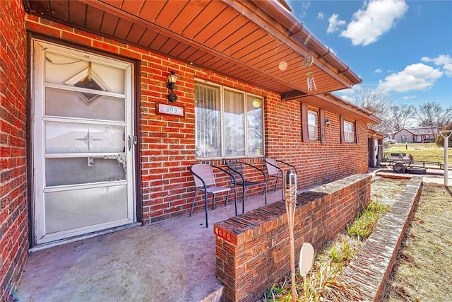 doorway to property with brick siding