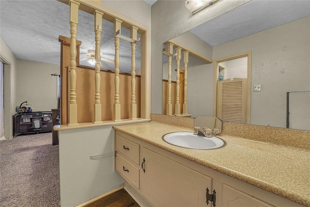 bathroom featuring a textured wall, a textured ceiling, and vanity