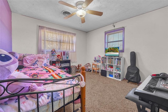 carpeted bedroom with visible vents, a ceiling fan, and a textured ceiling