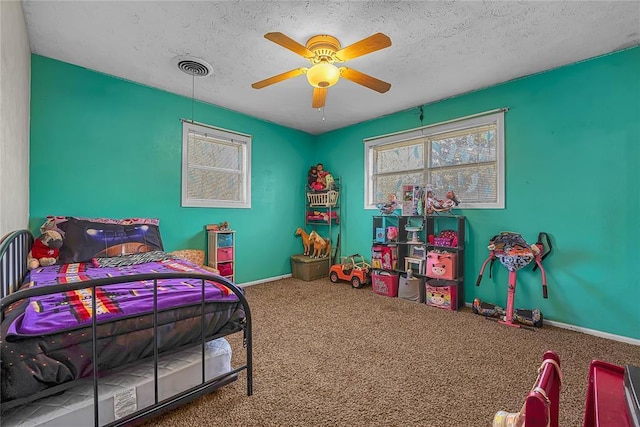 bedroom with baseboards, visible vents, ceiling fan, a textured ceiling, and carpet flooring