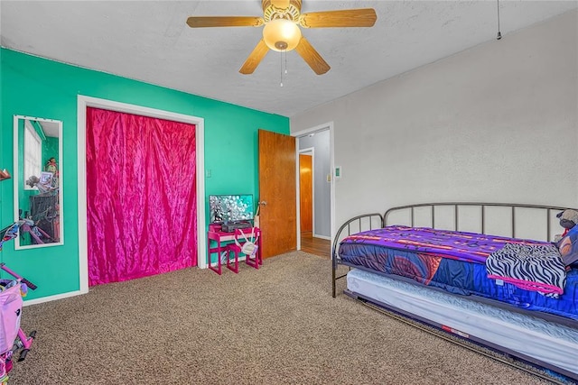 carpeted bedroom with a textured ceiling and a ceiling fan