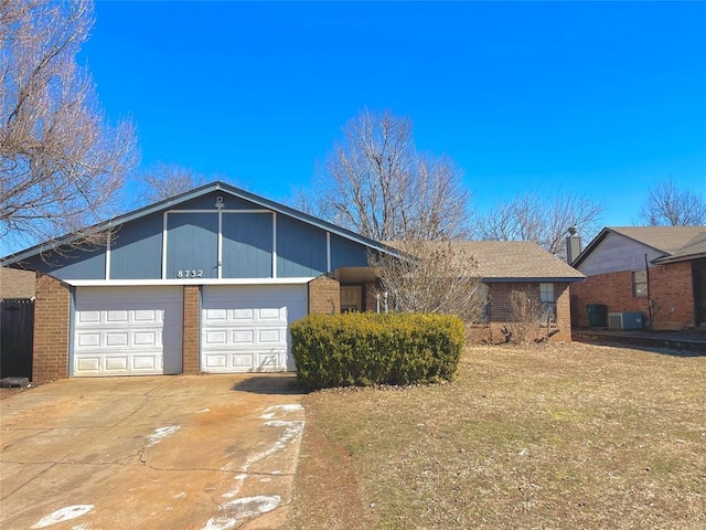 single story home with a garage, concrete driveway, brick siding, and cooling unit