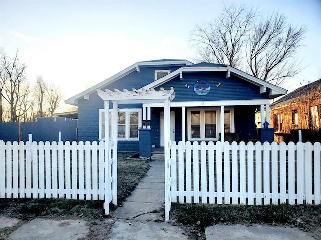 bungalow-style home with covered porch, a fenced front yard, and a pergola