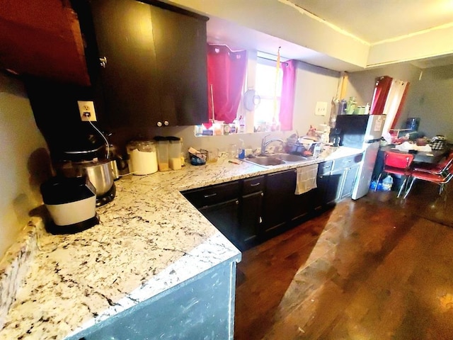 kitchen featuring light stone counters and a sink