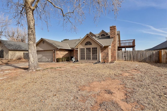 view of front of property with driveway, a chimney, an attached garage, fence, and brick siding