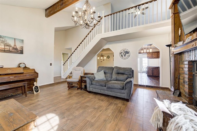 living area featuring a notable chandelier, arched walkways, and wood finished floors