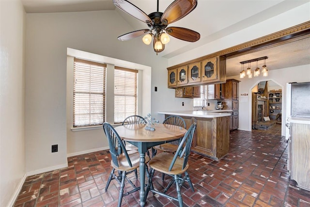 dining space with a healthy amount of sunlight, baseboards, and arched walkways