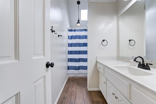 full bathroom featuring baseboards, wood finished floors, vanity, and a shower with curtain