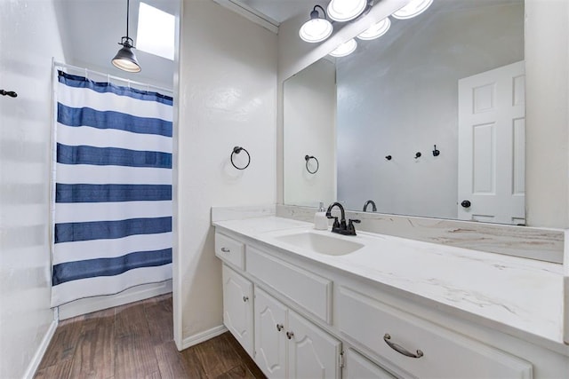 bathroom with vanity, baseboards, and wood finished floors