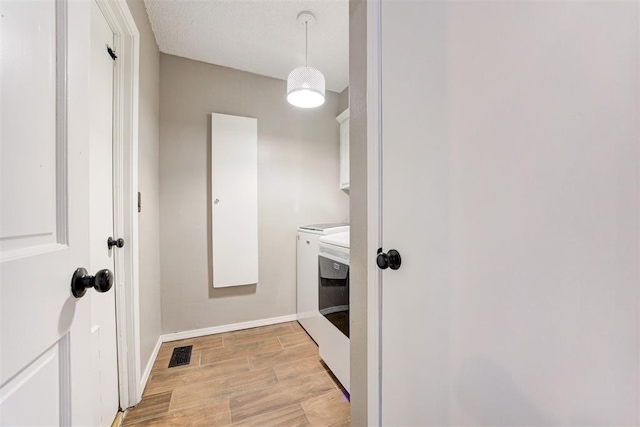 bathroom featuring visible vents, independent washer and dryer, baseboards, and wood finished floors