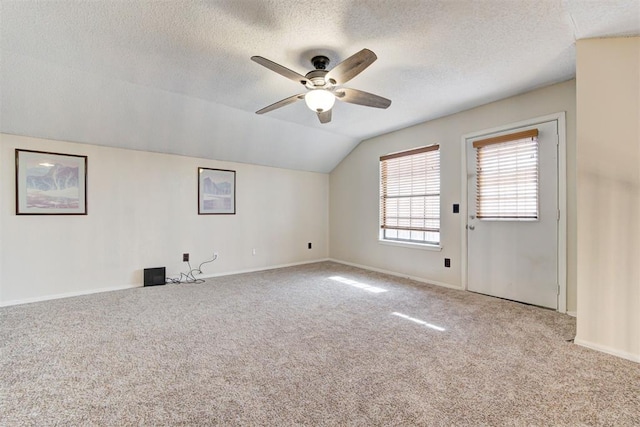 bonus room with light carpet, baseboards, a ceiling fan, vaulted ceiling, and a textured ceiling