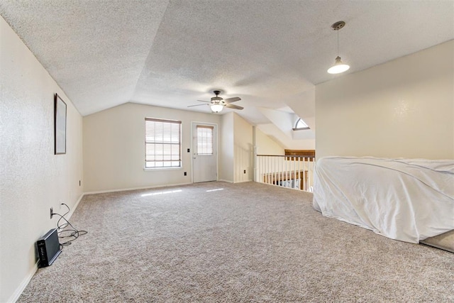 unfurnished bedroom featuring carpet, vaulted ceiling, a textured ceiling, and baseboards