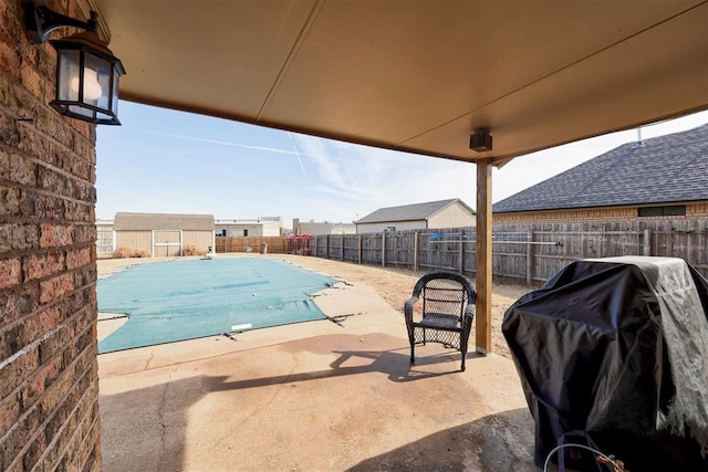 view of swimming pool featuring a fenced in pool, a fenced backyard, grilling area, and a shed