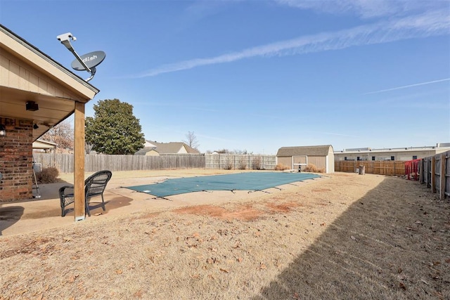 view of swimming pool featuring a fenced in pool, a fenced backyard, an outdoor structure, and a storage unit