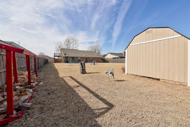 view of yard with a fenced backyard and an outbuilding