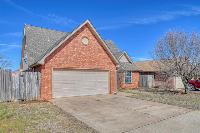 view of front facade featuring an attached garage, brick siding, fence, concrete driveway, and roof with shingles