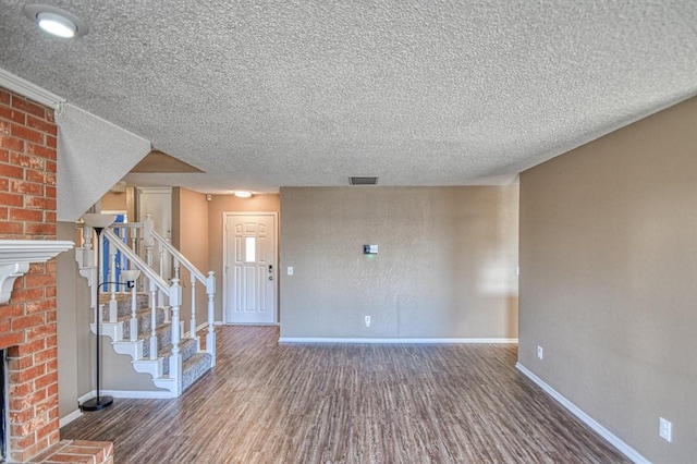 interior space with dark wood-style floors, a fireplace, visible vents, baseboards, and stairs