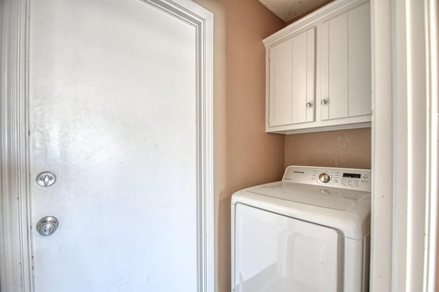 washroom with washer / dryer and cabinet space