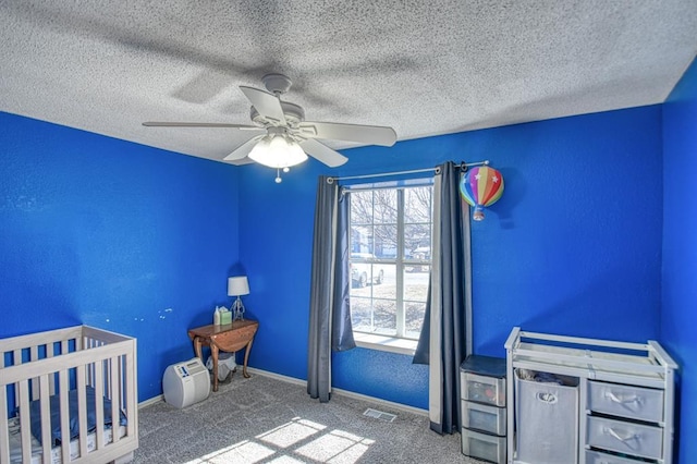 unfurnished bedroom with baseboards, a textured ceiling, visible vents, and carpet flooring