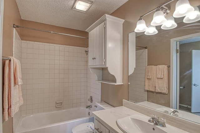 bathroom featuring shower / washtub combination, toilet, a textured ceiling, and vanity