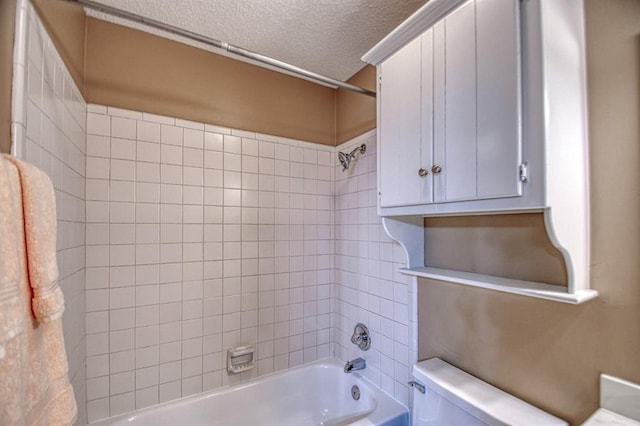 bathroom with toilet, a textured ceiling, and shower / bathtub combination