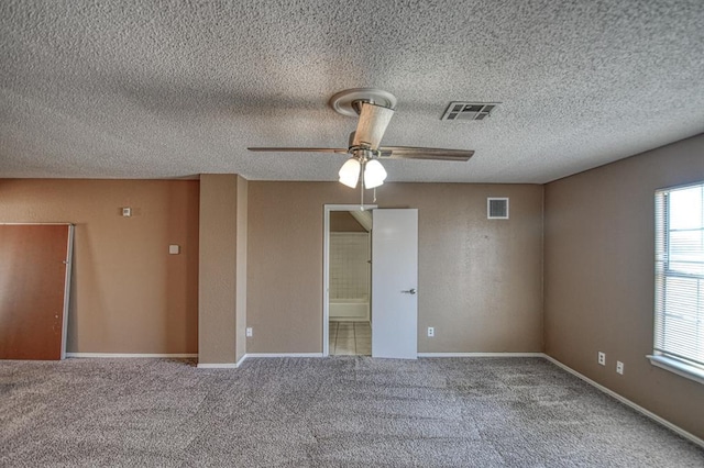 empty room with carpet, visible vents, and baseboards