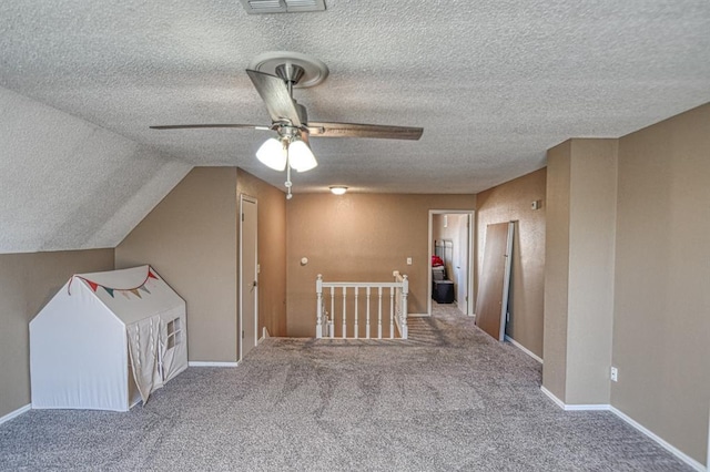 bonus room with carpet floors, lofted ceiling, ceiling fan, a textured ceiling, and baseboards