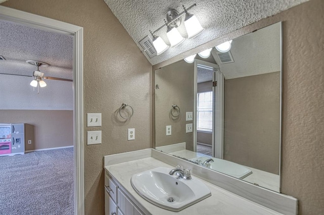 bathroom featuring vaulted ceiling, a textured wall, and a textured ceiling