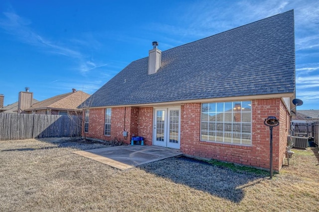 rear view of property with a chimney, roof with shingles, fence, a patio area, and brick siding